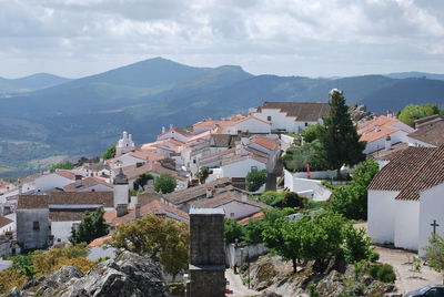 Town by mountains against sky