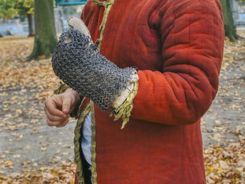 Midsection of person wearing oven mitten