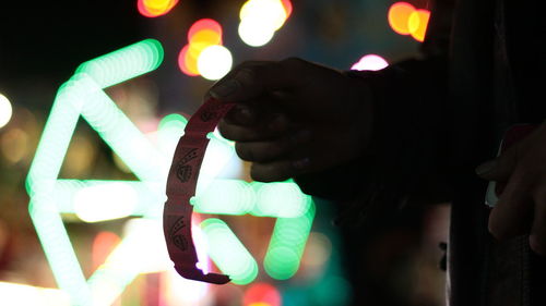 Close-up of hand holding illuminated light painting at night