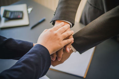 Midsection of man holding hands on table