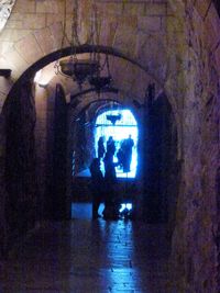 People in illuminated corridor