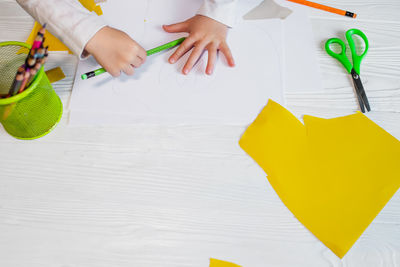 Cropped hand of woman holding umbrella on table