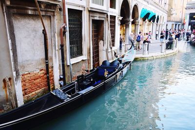 People on boats in canal along buildings