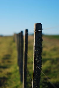 Close-up of wooden fence on field against sky