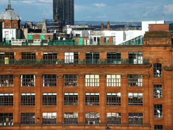 Buildings in city against cloudy sky