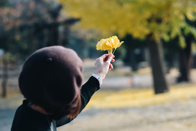 Portrait of man holding yellow flowering plant