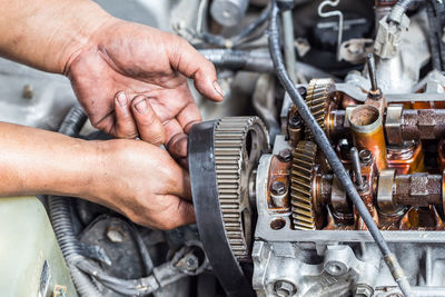 Cropped hand of man working at machine