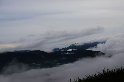 Scenic view of mountains against cloudy sky