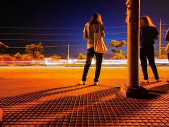 Full length of friends standing at night