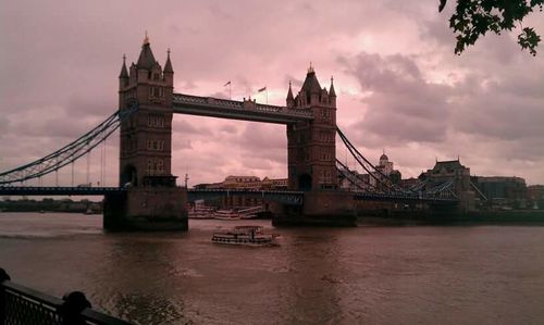 Bridge over river against cloudy sky