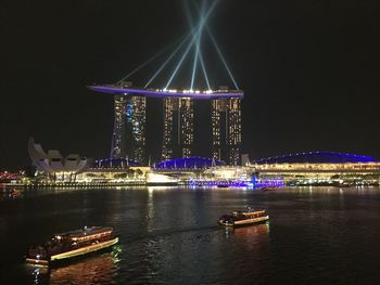 Illuminated bridge over river at night