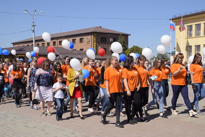 Group of people on street against buildings