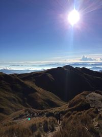 Scenic view of landscape against bright sun