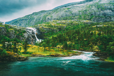 Scenic view of river amidst mountains against sky