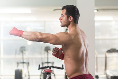 Muscular shirtless man standing in gym