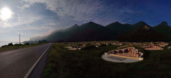 Road leading towards mountains against sky