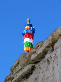 Low angle view of flags against clear blue sky