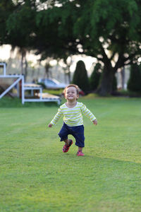 Full length of boy playing in grass