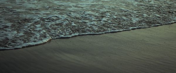 High angle view of water flowing on beach