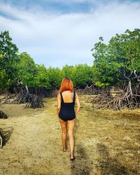 Rear view of woman standing by tree