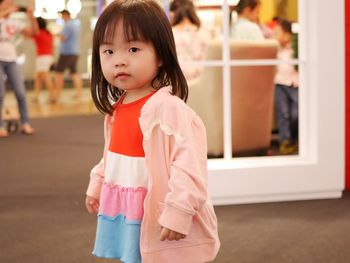 Portrait of cute girl standing at home