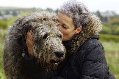 Close-up of woman kissing hairy dog