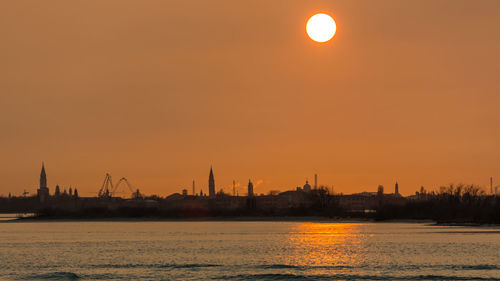 View of city at waterfront during sunset