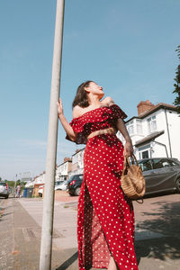 Woman standing against sky in city