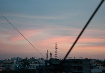 Buildings in city against sky at sunset