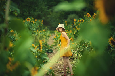 Woman standing by plants on field