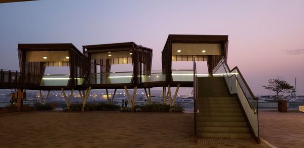 Low angle view of illuminated buildings against clear sky at sunset