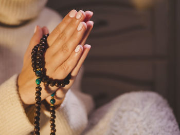 Cropped hands with rosary beads