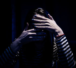 Midsection of woman covering face with hands