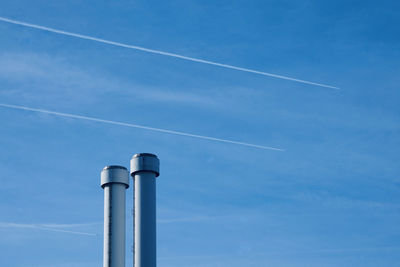 Low angle view of electricity pylon against blue sky