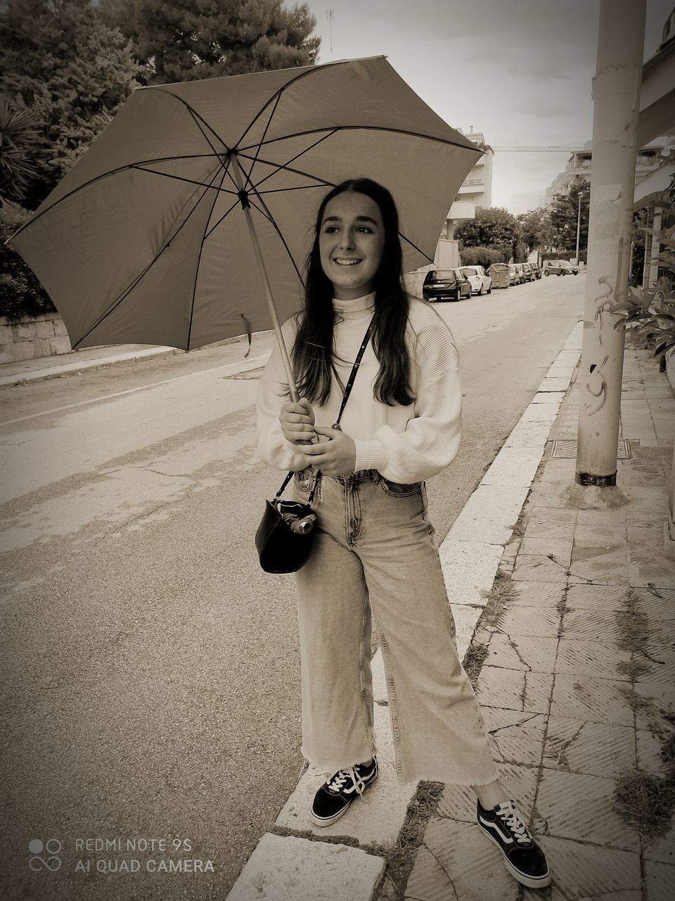 PORTRAIT OF YOUNG WOMAN STANDING IN RAIN ON STREET