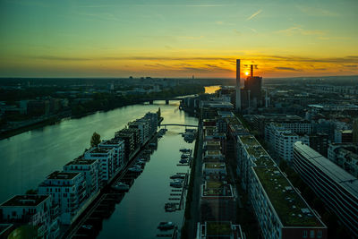 High angle view of river in city against sky during sunset