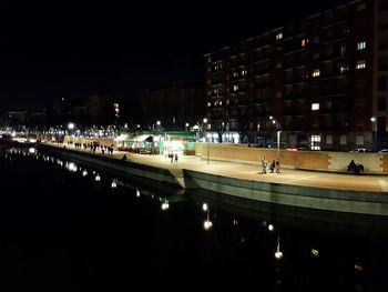 Illuminated city against sky at night