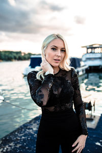 Portrait of woman standing against water