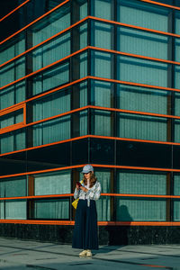 Rear view of woman standing against building