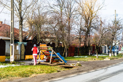 People standing by bare tree in playground