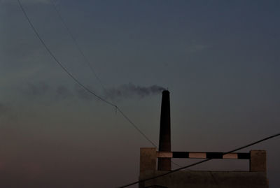 Low angle view of smoke emitting from chimney against sky