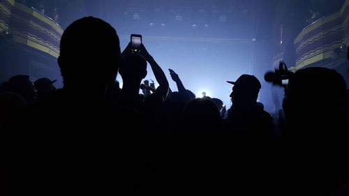 Silhouette people enjoying in music concert at night