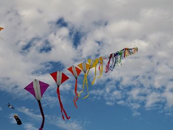 Low angle view of flags hanging against sky