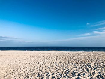 Scenic view of beach against blue sky