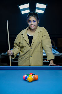 Portrait of woman playing pool