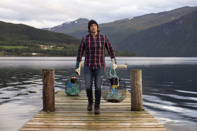 Portrait of smiling standing on lake against mountains