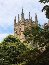 Low angle view of historic building by trees against sky