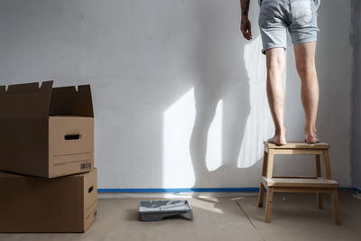 Low section of man standing on step stool