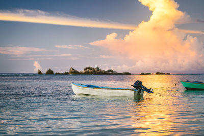 Boat in sea against sky during sunset