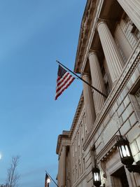 Low angle view of flag on building against sky